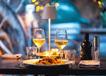 tavolo apparecchiato con pietanze e calici di vino