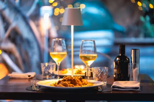 tavolo apparecchiato con pietanze e calici di vino