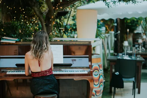 donna che suona il pianoforte in sala